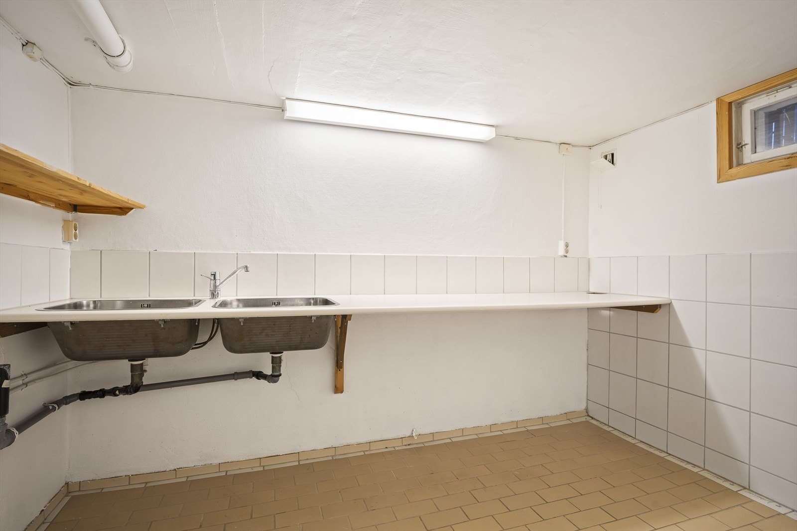 Vaskerom med flislagt gulv og praktisk benkeplate. Opplegg for vaskemaskin og varmekabler i gulv. Galleribilde