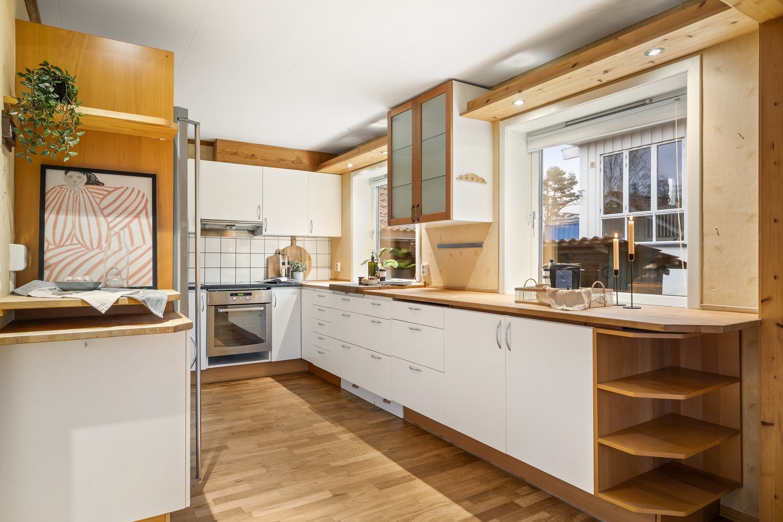 Slette, lyse fronter og en kombinasjon av heltre og laminerte benkeplater. Galleribilde