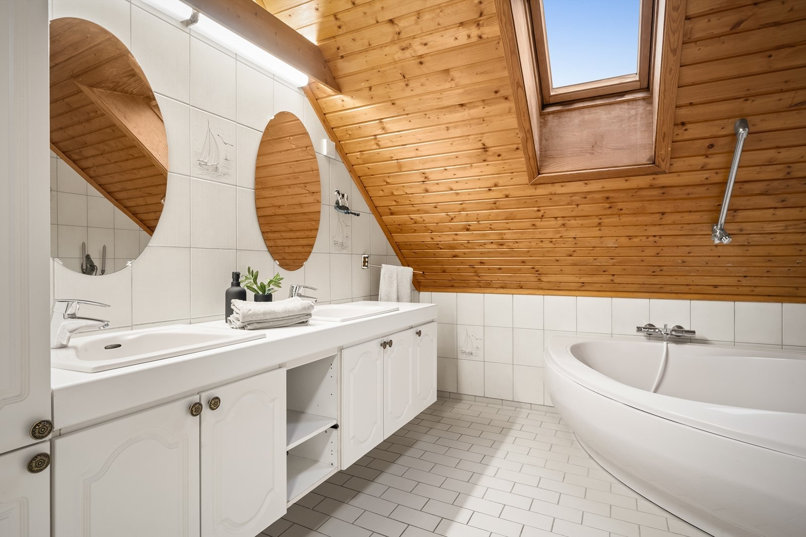 Badet består av et frittstående badekar, toalett, innredning med to servanter og underskap. Galleribilde