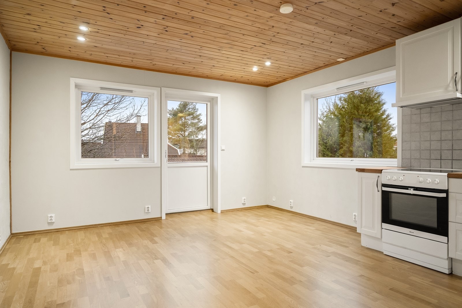 Stue med lysmalte overflater og parkett på gulv og det er utgang til en balkong på 9 m². Galleribilde