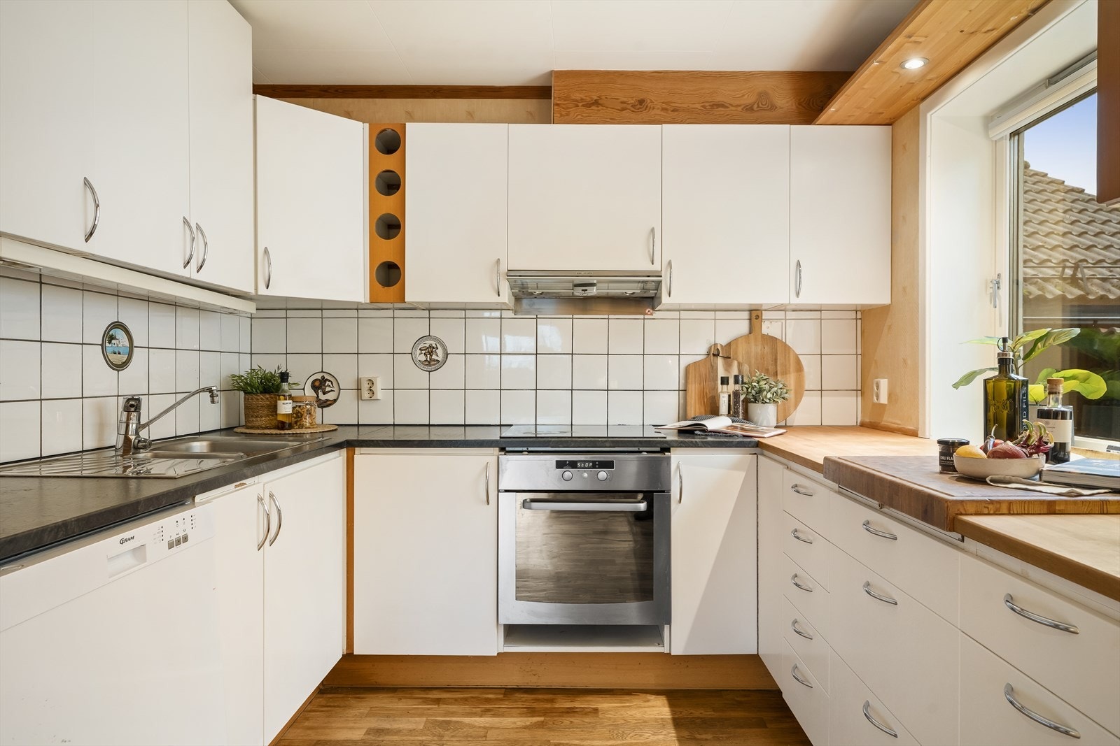 Integrerte hvitevarer som komfyr og koketopp. Frittstående kjøleskap og oppvaskmaskin. Galleribilde