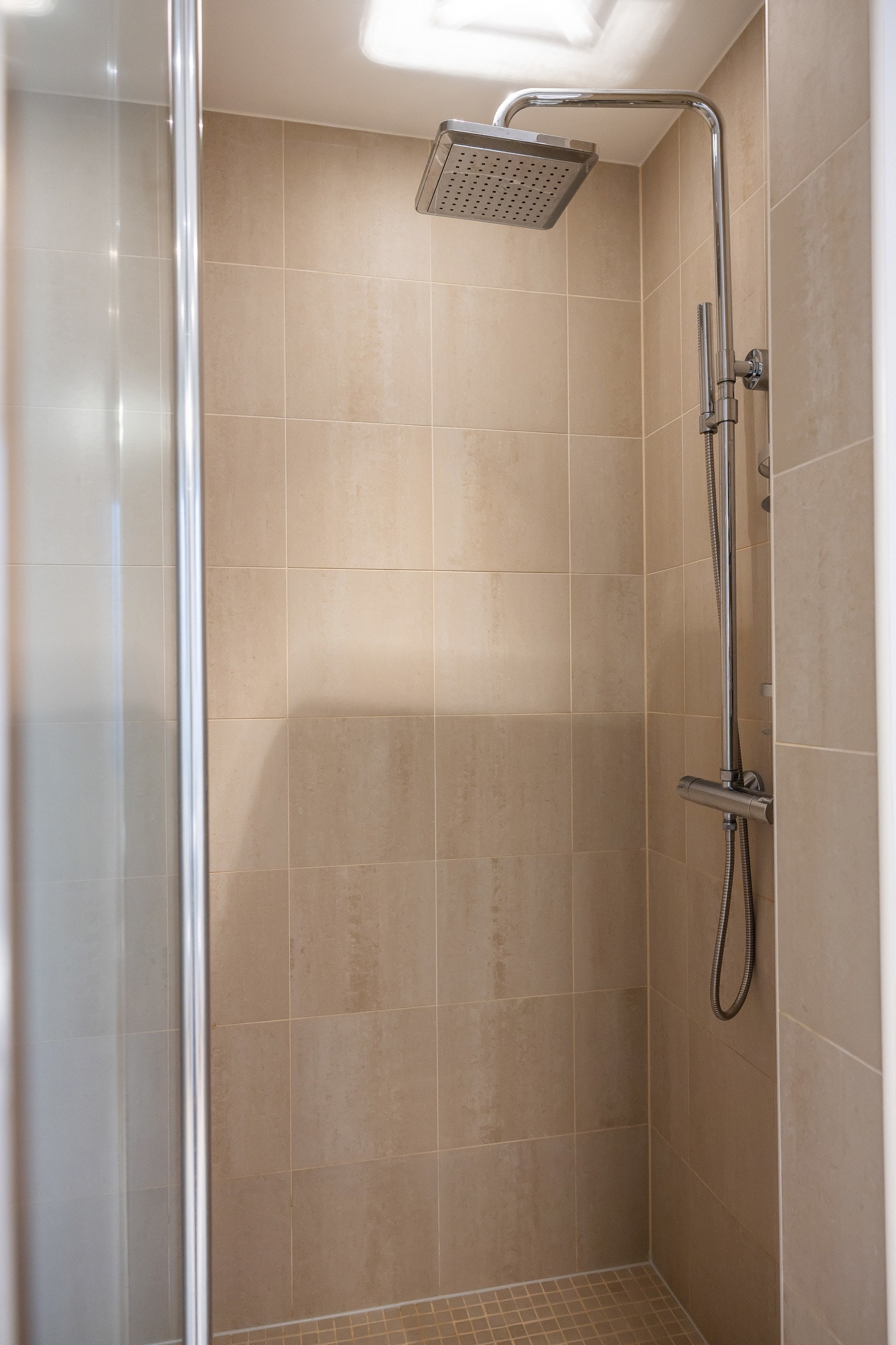 Badet er utstyrt med innmurt dusjnisje, servant med innredning, toalett og hyllesystem. Galleribilde