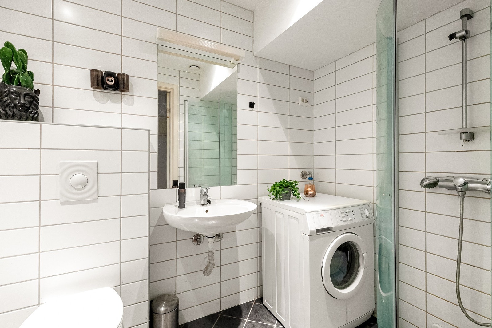 Romslig baderom med vegghengt toalett, dusjhjørne, servant og opplegg for vaskemaskin. Bad ble oppusset i 2006. Galleribilde