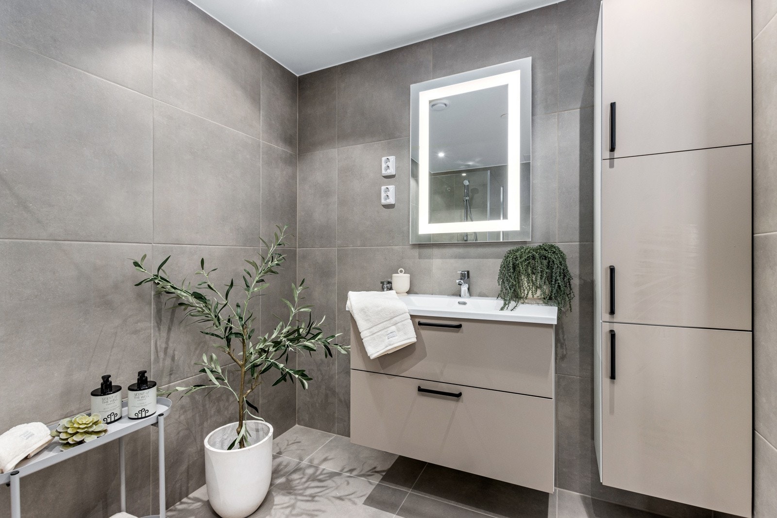 Flislagt og lekkert bad med opplegg for vaskemaskin og tørketrommel. Galleribilde