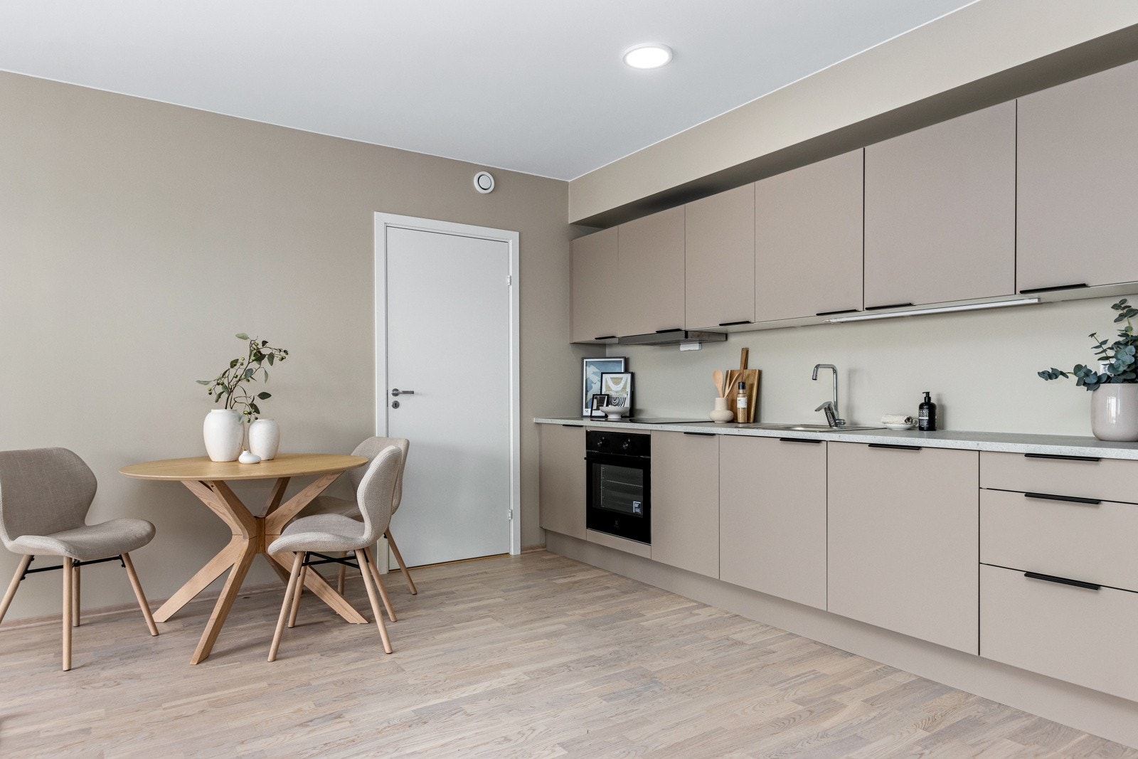 Kjøkken med integrerte hvitevarer som komfyr, platetopp, oppvaskmaskin og kombiskap. Galleribilde