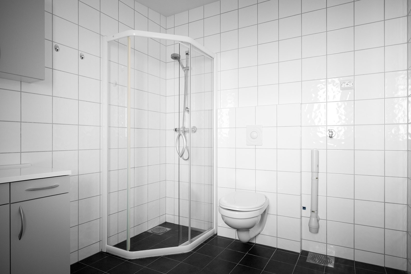 Tidløst bad med fliser på gulv og i dusjsone, samt opplegg for vaskemaskin. Galleribilde