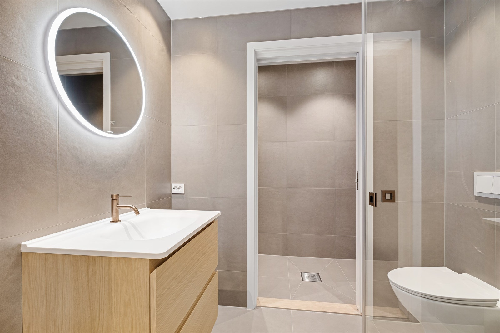 Flott og delikat bad med innredning i lys eik, wc, dusj og inngang til flislagt vaskerom. Galleribilde