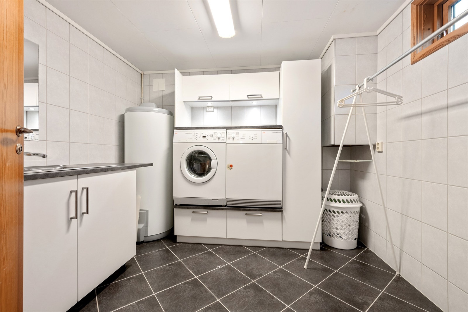 Vaskerom i underetasjen med innredning og opplegg for vaskemaskin og tørketrommel Galleribilde