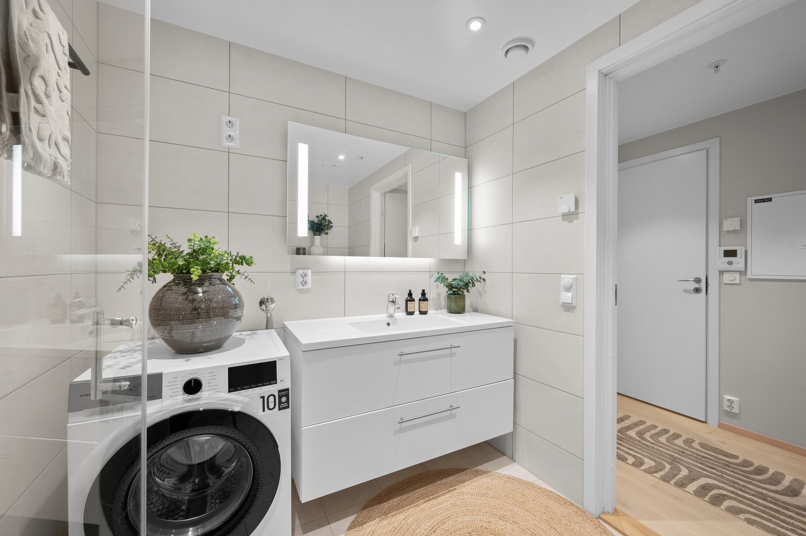 Delikat baderom med gulvvarme og opplegg for vaskemaskin og tørketrommel Galleribilde