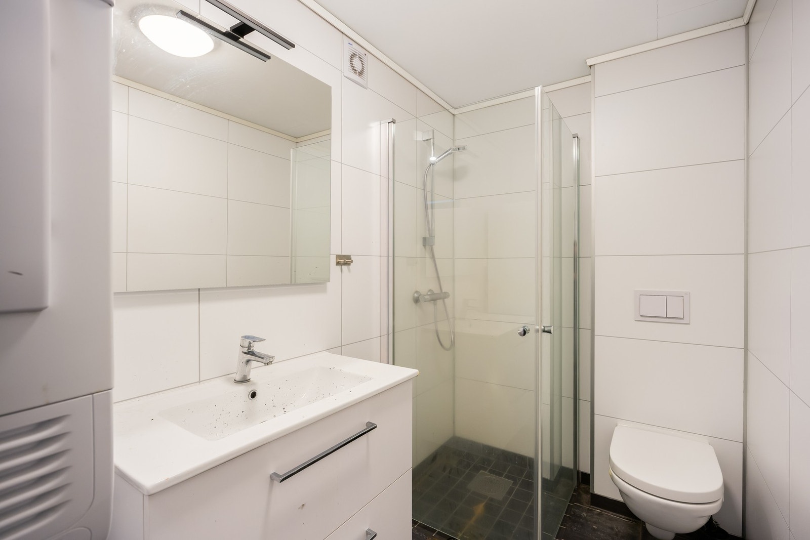 Dusjhjørne, wc, servantskap samt opplegg for vaskemaskin og tørketrommel. Galleribilde