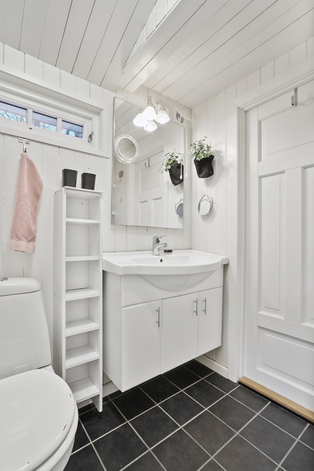 Innredet med servantinnredning, speil, toalett, opplegg for vaskemaskin og dusjsone. Galleribilde