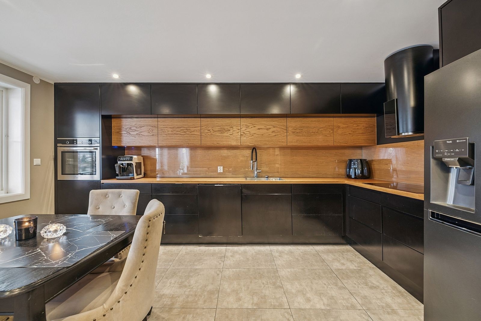 Stilren kjøkkeninnredning med heltre benkeplate og spotlights over kjøkkenbenk gir godt arbeidslys. Galleribilde