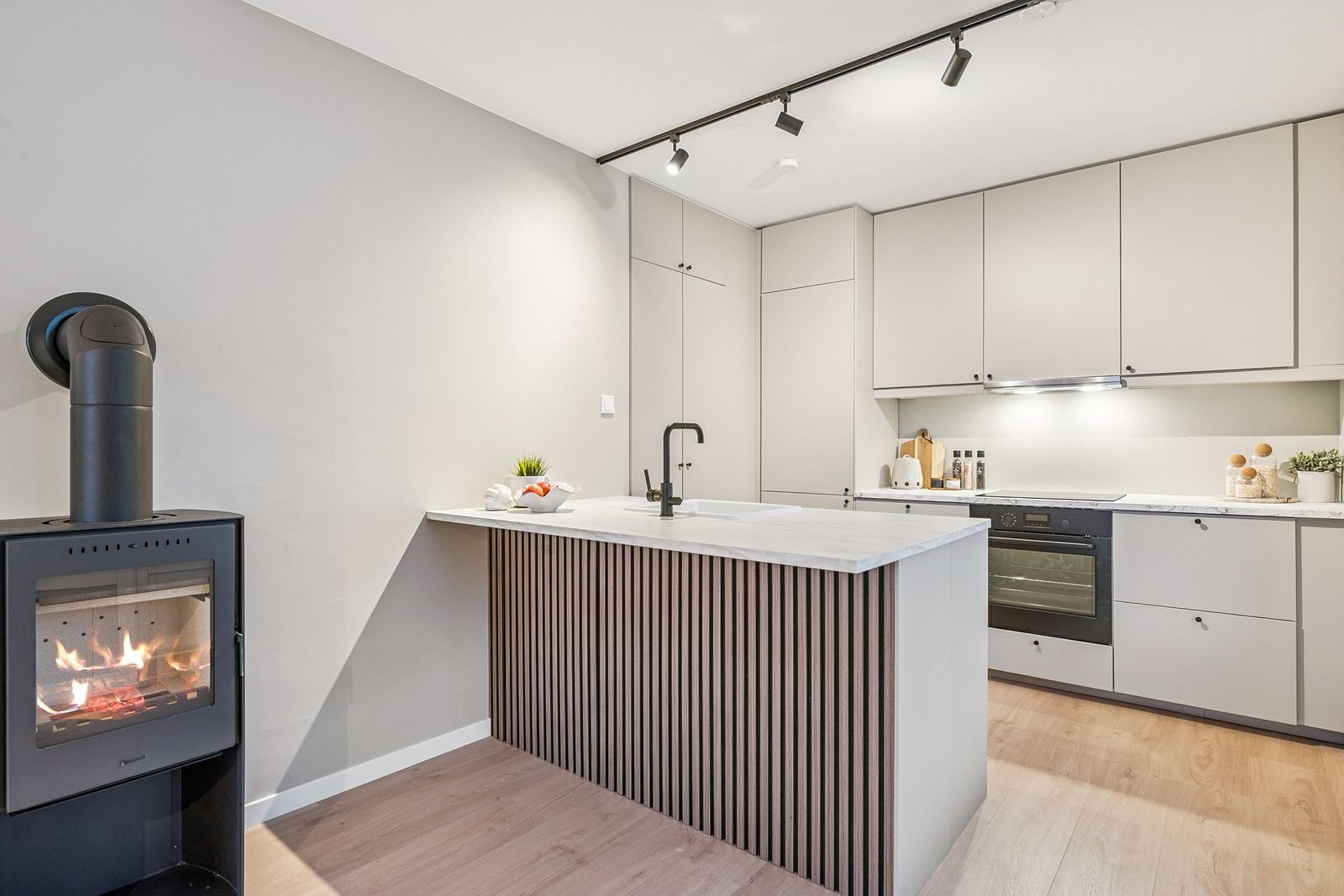 Gjennomført og moderne kjøkken som balanserer sosialt samvær og praktisk bruk på en elegant måte. Galleribilde