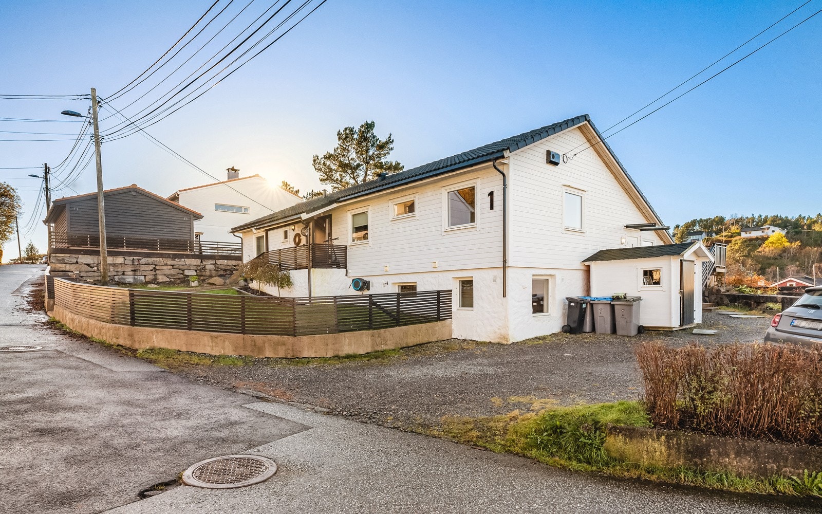 God plass til flere biler i oppkjørsel og på siden av grus. Galleribilde