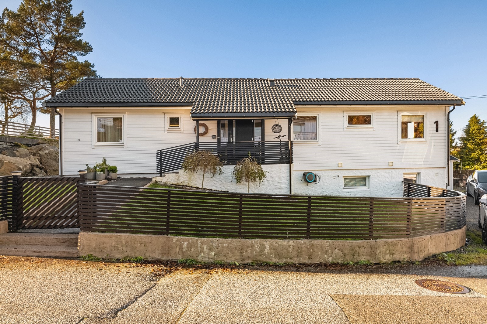 Eneboligen har en godt opparbeidet tomt med hage, terrasse på 67 kvm og flere biloppstillingsplasser Galleribilde