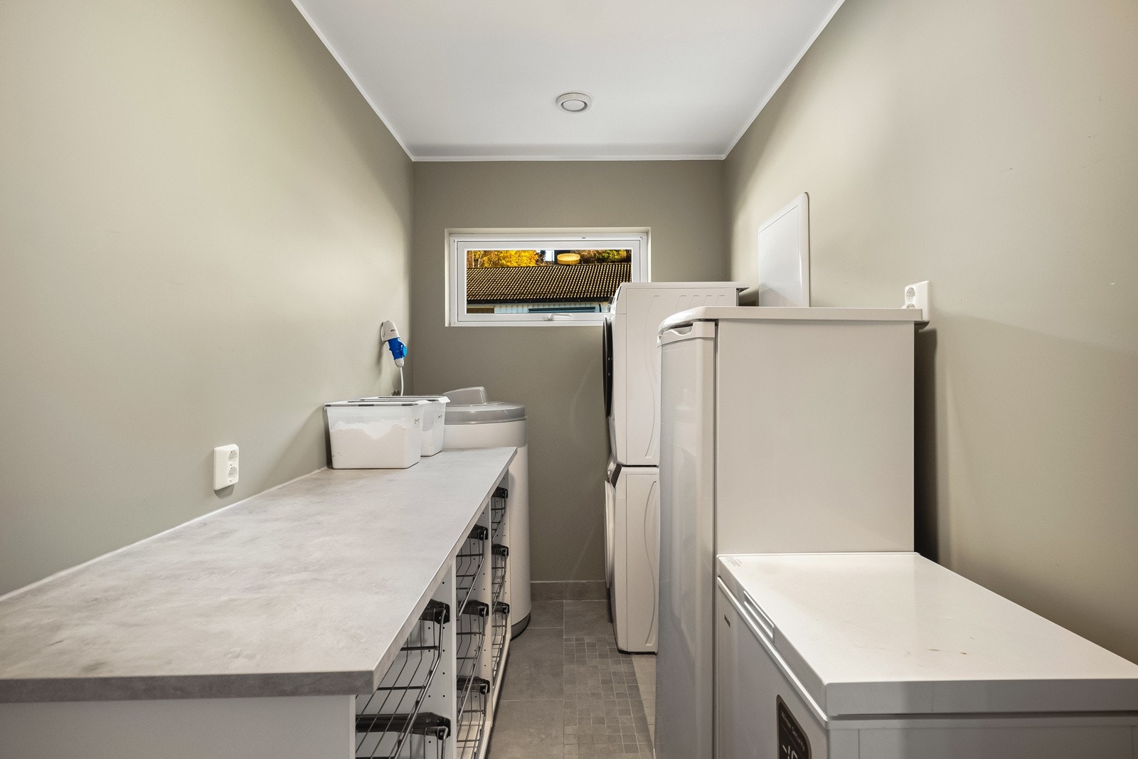 Praktisk vaskerom i tilknytning kjøkken med alt en skulle trenge av skapplass, opplegg for vaskemaskin og utslagsvask. Galleribilde