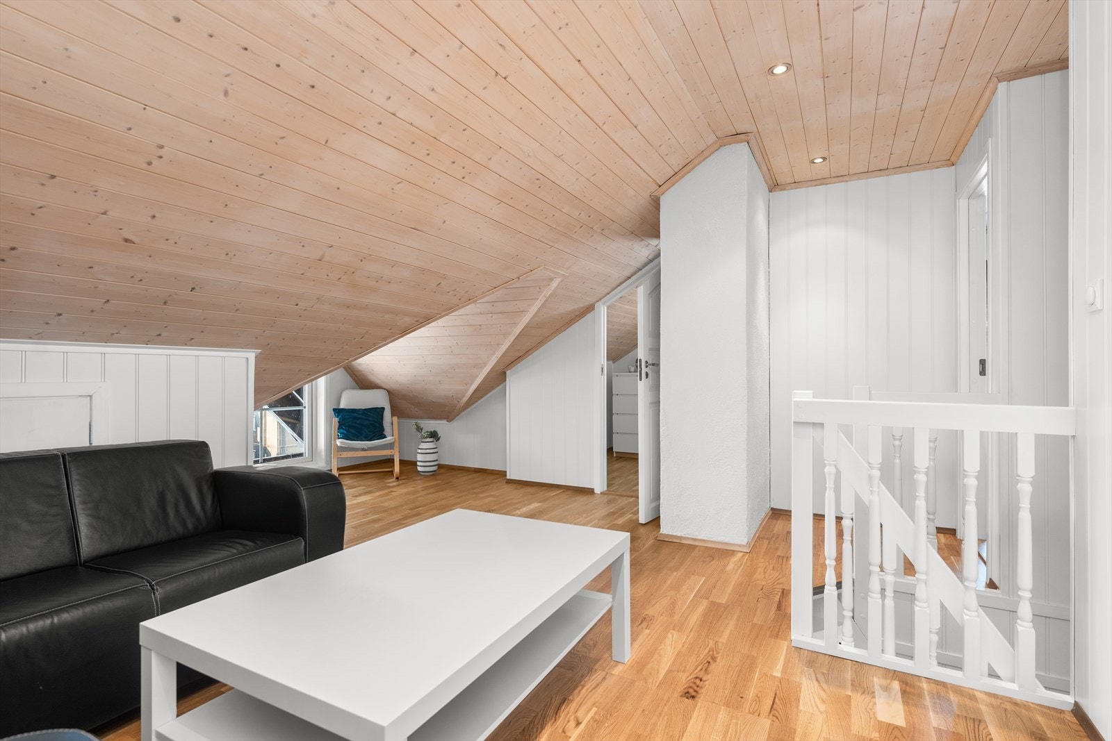 Lys og innbydende loftsstue med skråtak og parkettgulv. Galleribilde