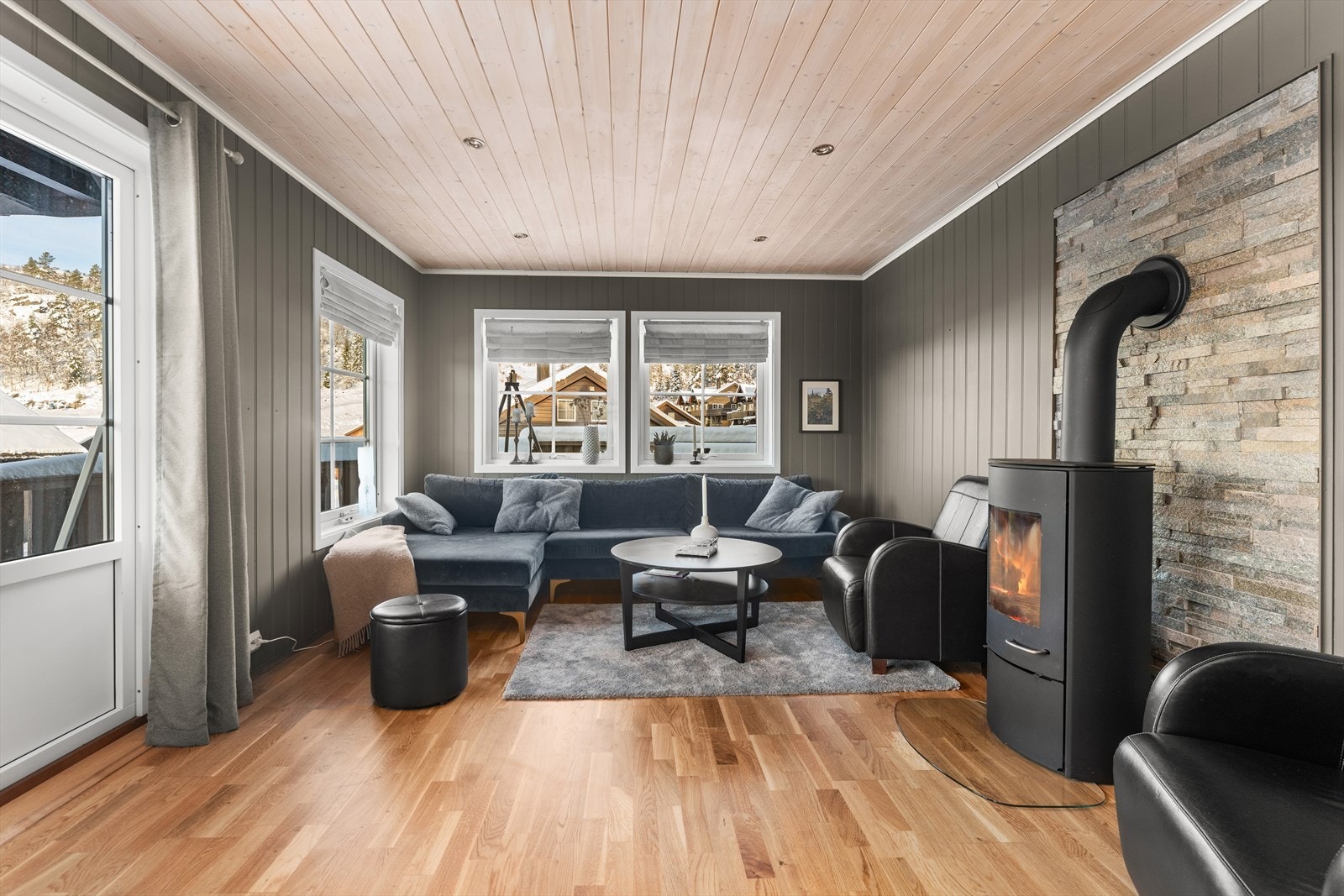 Lys og innbydende stue med store vindusflater og peis. Galleribilde