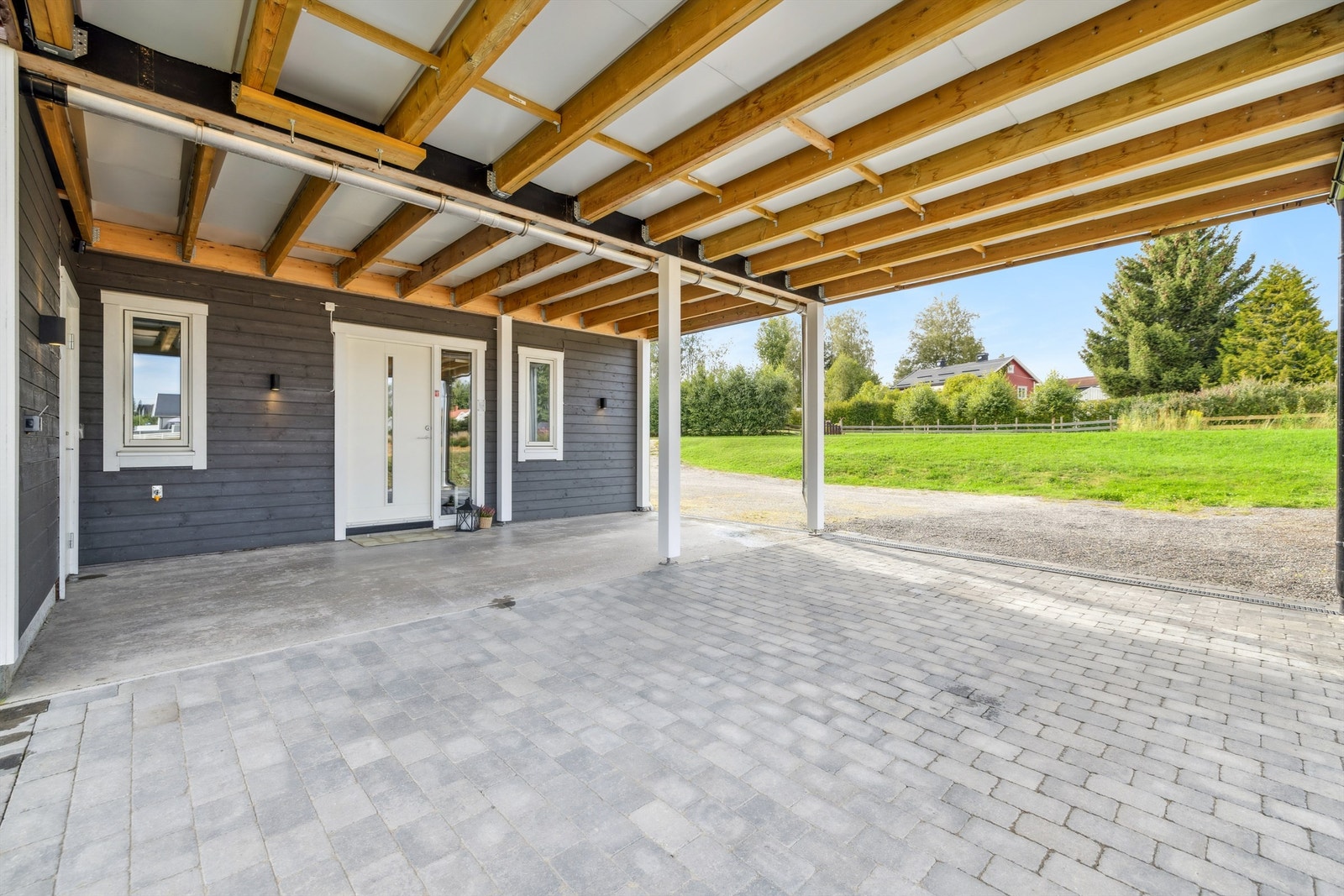 Overbygget inngangsparti og to praktiske biloppstillingsplasser i carport. Galleribilde