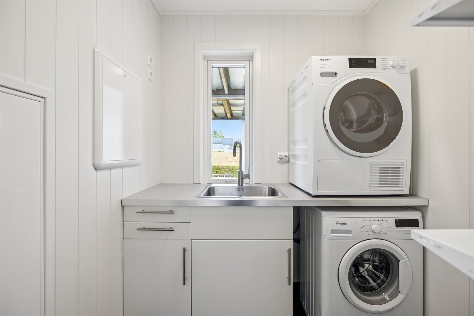 Praktisk, separat vaskerom med utslagskum og opplegg for vaskemaskin. Galleribilde