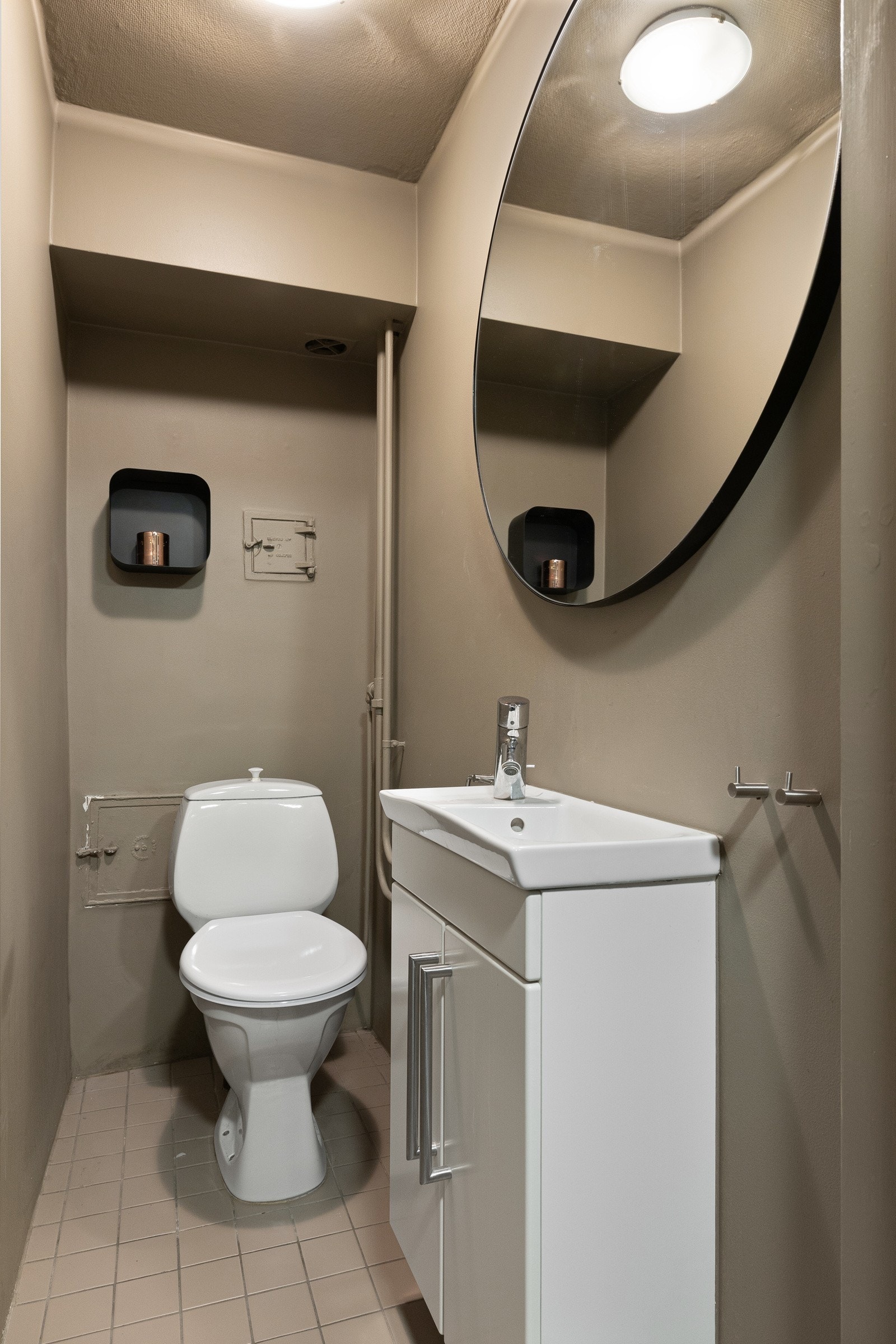 Praktisk gjestetoalett med toalett, servant med underskap og stort speil som gir en luftig følelse i rommet. Enkelt og funksjonelt plassert like ved oppholdsrommene, perfekt for daglig bruk og når du har besøk. Galleribilde