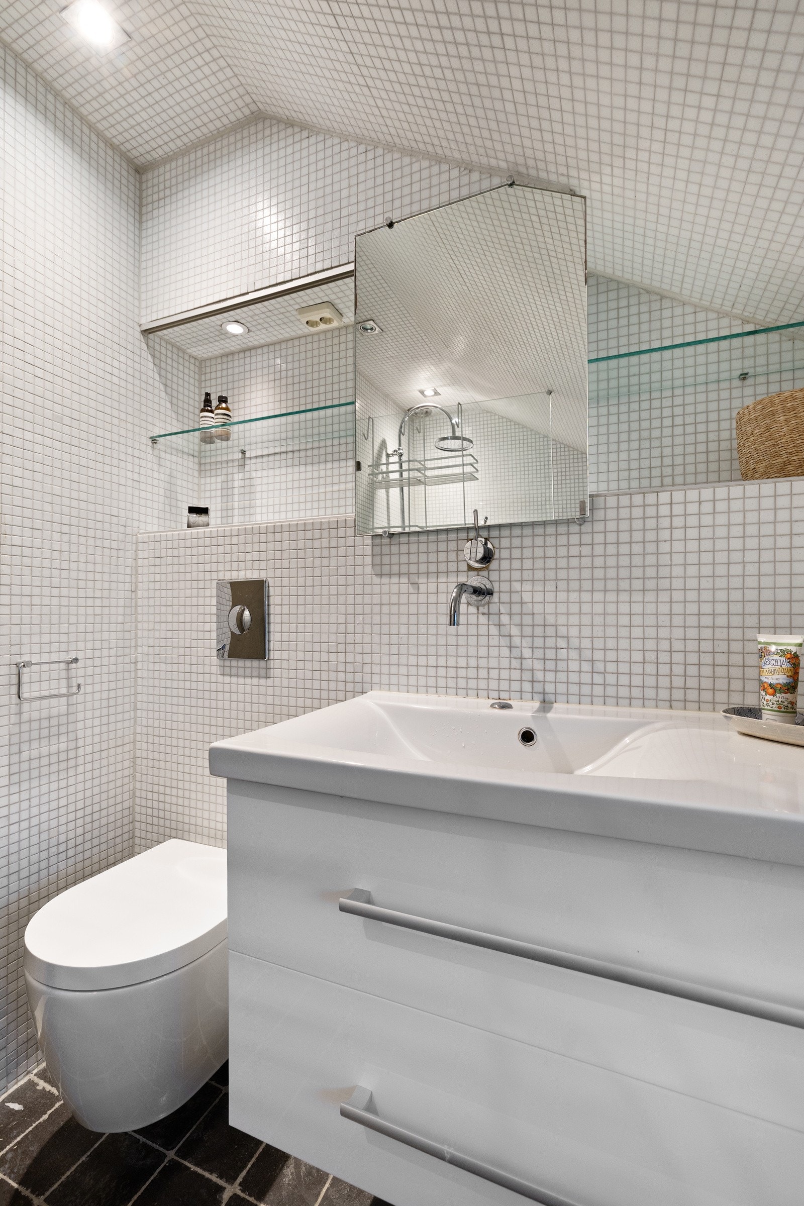 Badet fra 2010 er innredet med dusjnisje med glassvegg, vegghengt toalett og møbel med nedsenket servant og speil. Galleribilde