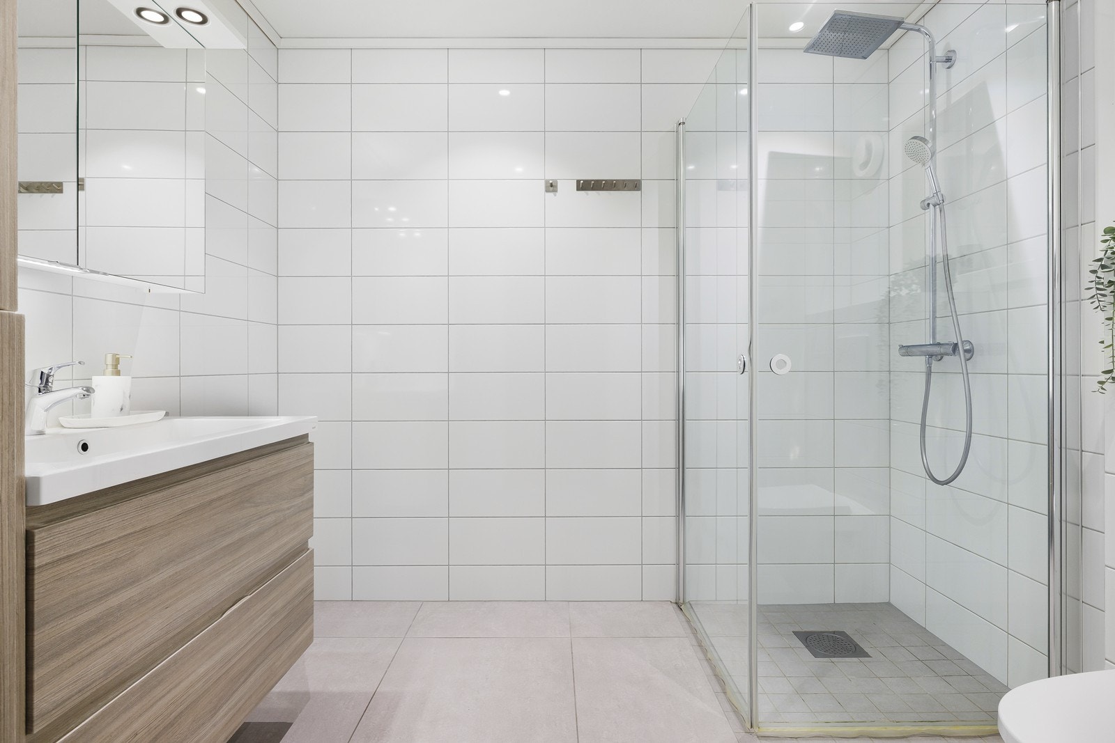 Flott baderom med delikate fliser på gulv, fine detaljer og behagelig belysning. Galleribilde