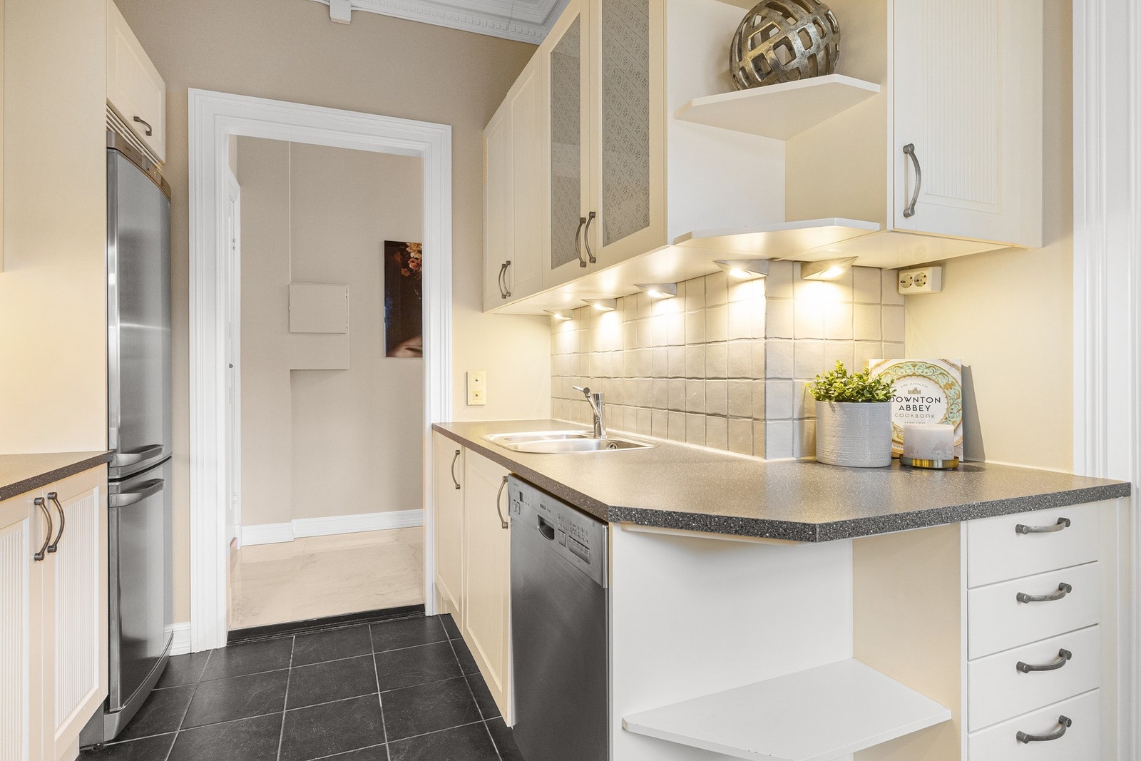 Følgende hvitevarer er integrert: stekeovn fra AEG, keramisk platetopp fra AEG, oppvaskmaskin fra Bosch, kombiskap fra Bosch, avtrekksvifte med avtrekk ut og komfyrvakt. Galleribilde