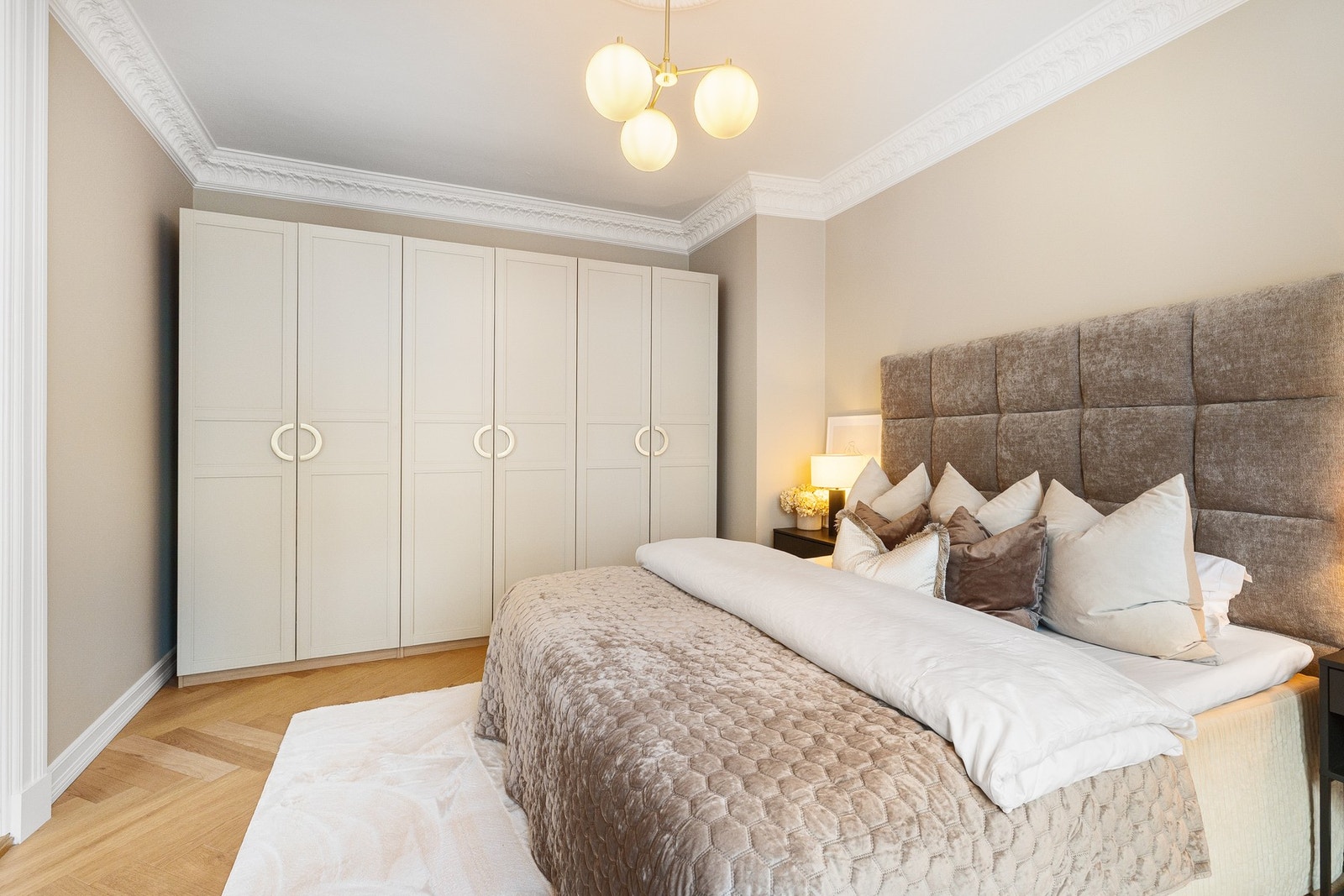 Raus garderobe med håndtak fra Love Handles Oslo kombinerer funksjonalitet med stilfull design i dette sofistikerte soverommet. Galleribilde