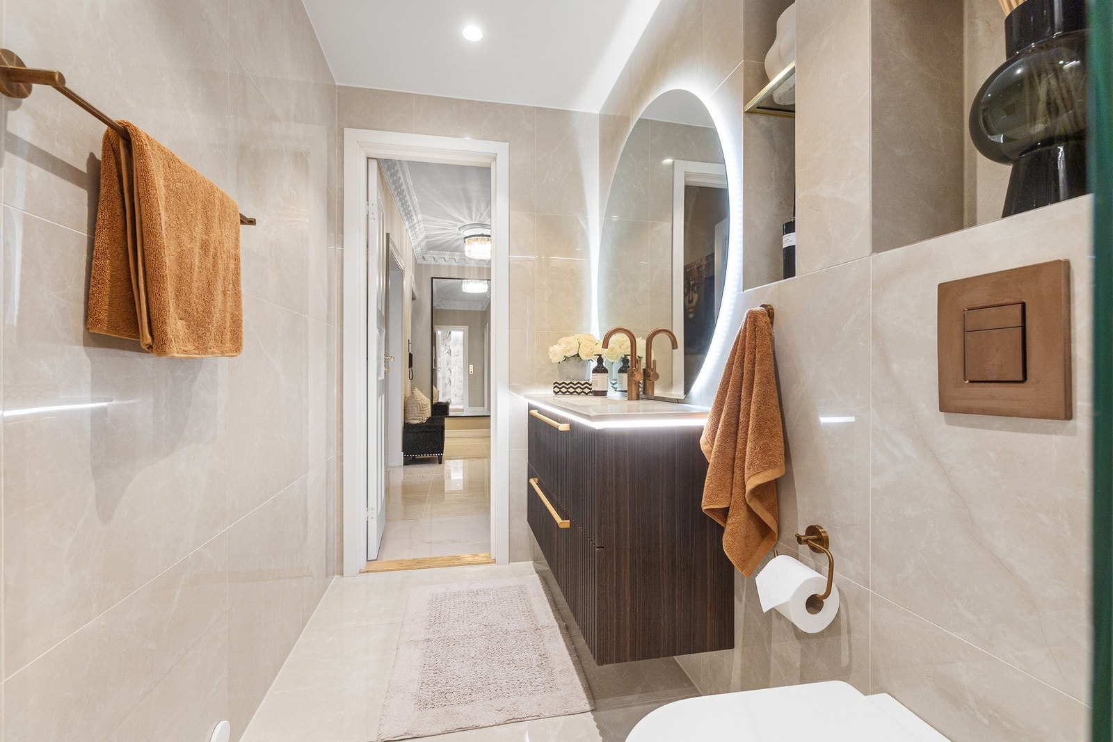 Baderommet er innredet med stilren baderomsinnredning fra Scala Bad, supplert av en elegant nisje med hyller som gir både praktisk oppbevaring og et raffinert uttrykk. Galleribilde