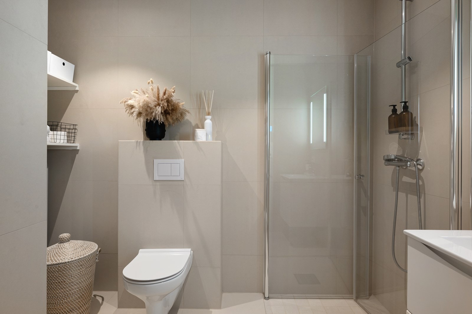 Delikat helfliset bad med 60x60 fliser vegghengt wc, dusjhjørne og varme i gulv for ekstra komfort. Galleribilde