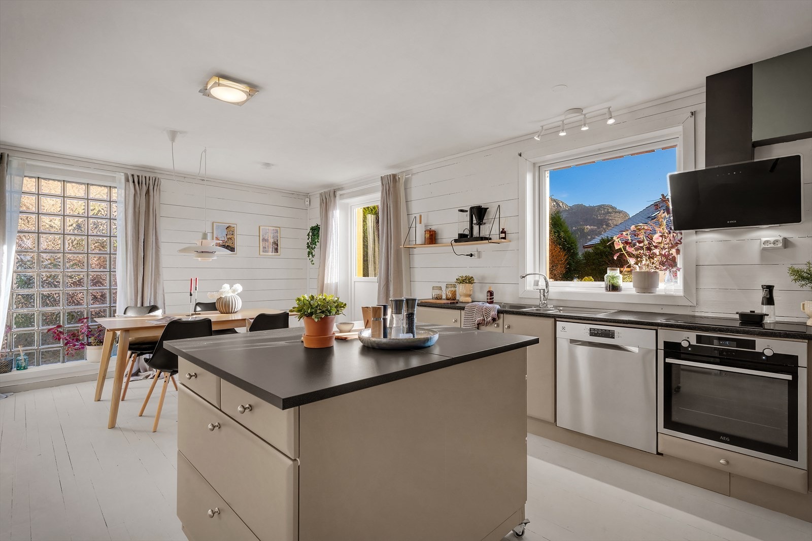 Kjøkkenet har glatte fronter og laminat benkeplate med nedfelt stålvask og platetopp Galleribilde