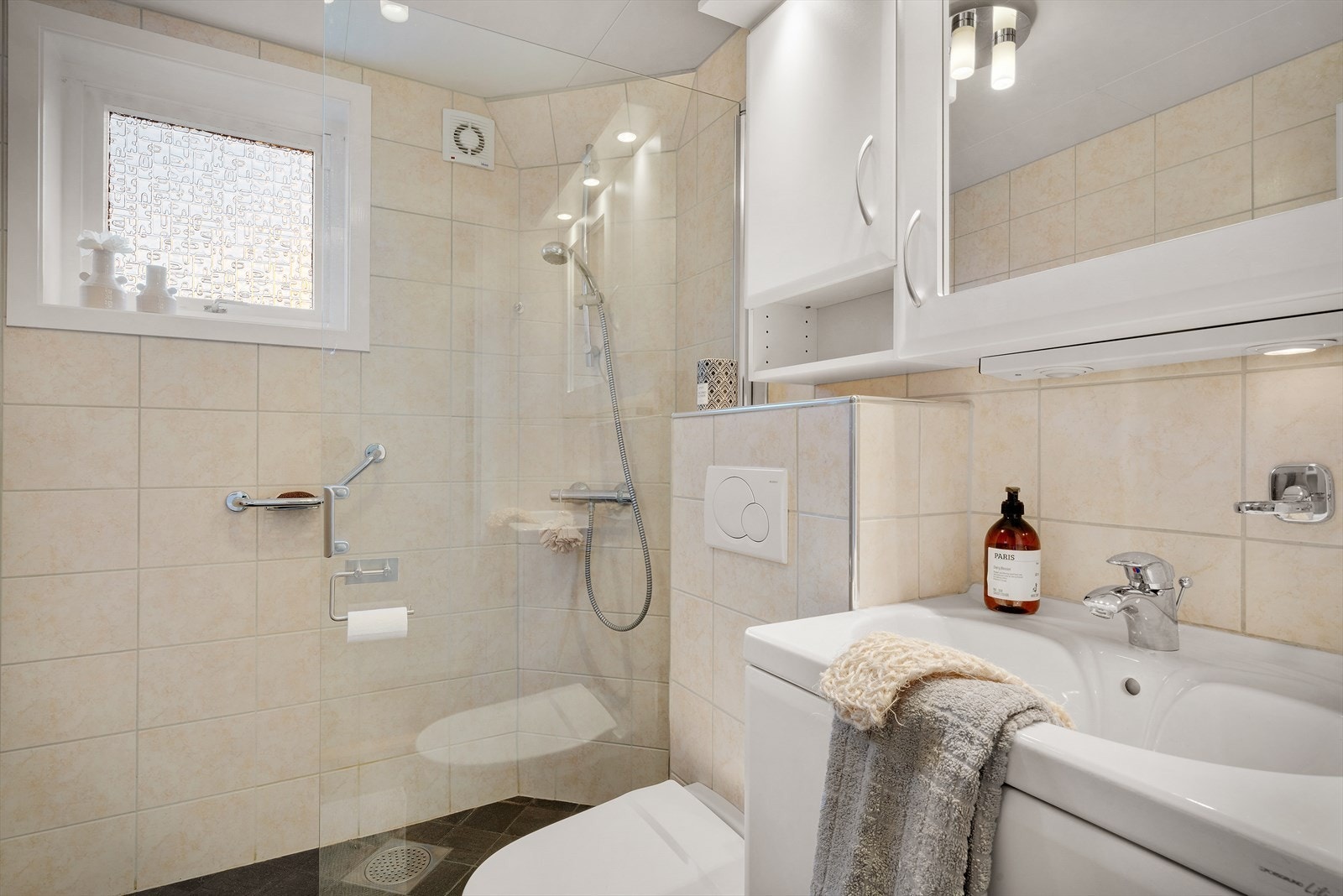 Badet er innredet med dusjhjørne, vegghengt toalett og servant Galleribilde