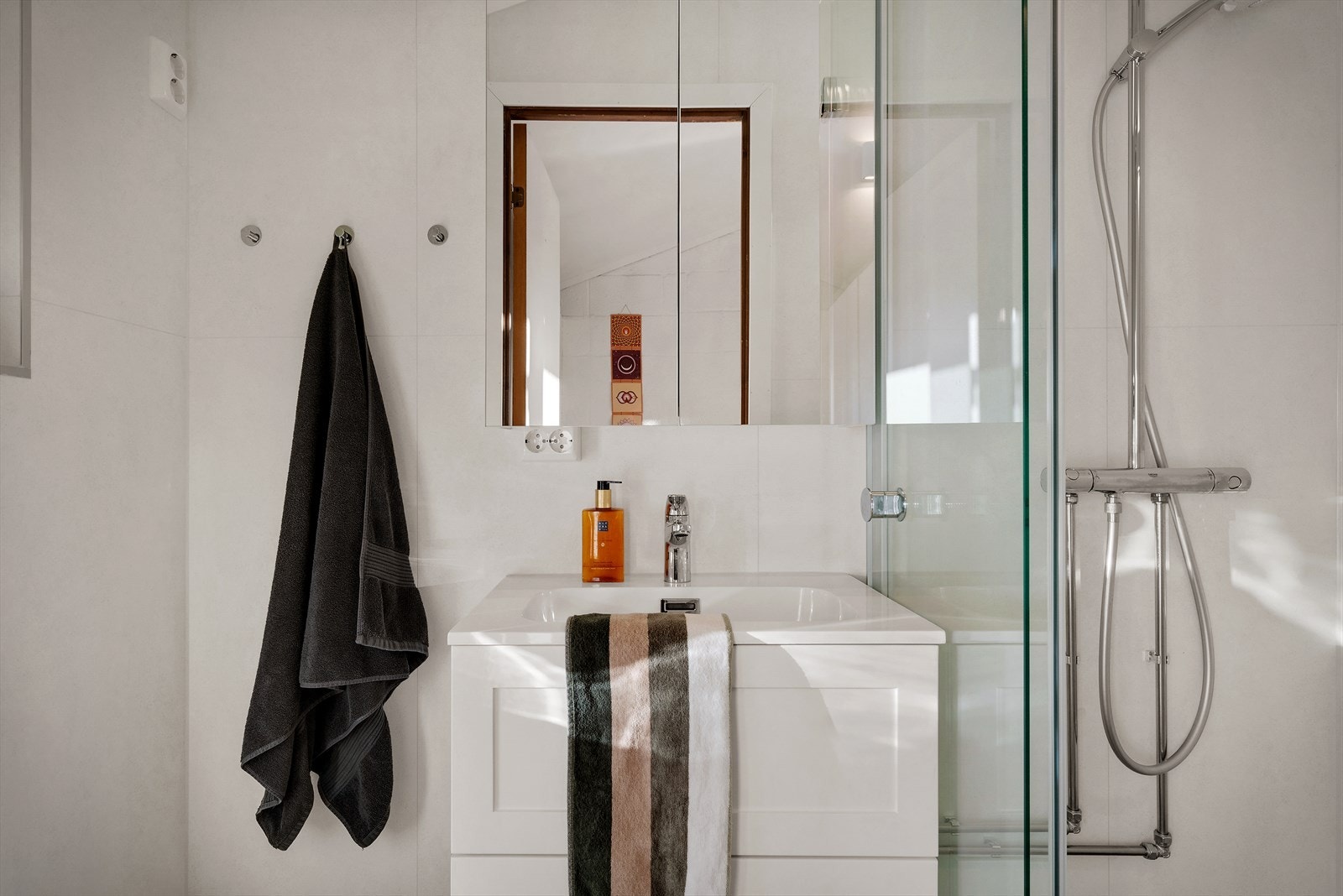 Badet er innredet med vegghengt toalett, vask og dusjhjørne Galleribilde