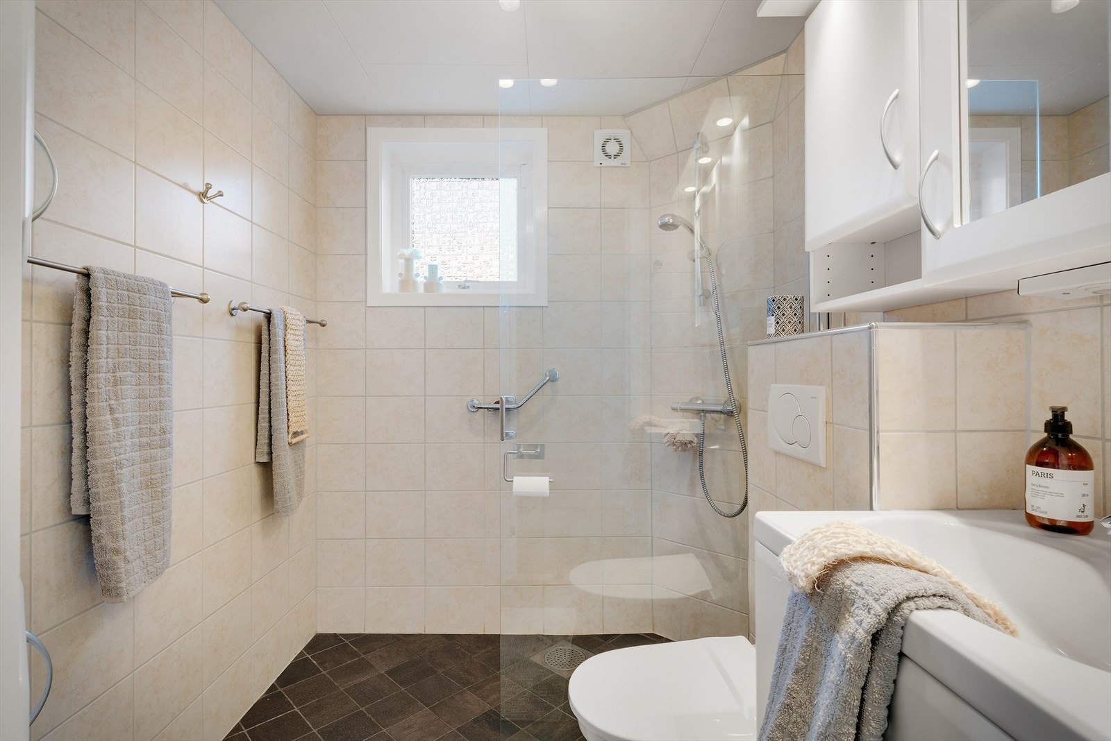 Badet har fliser på veggene og gulvet. Gulvet har varmekabler Galleribilde