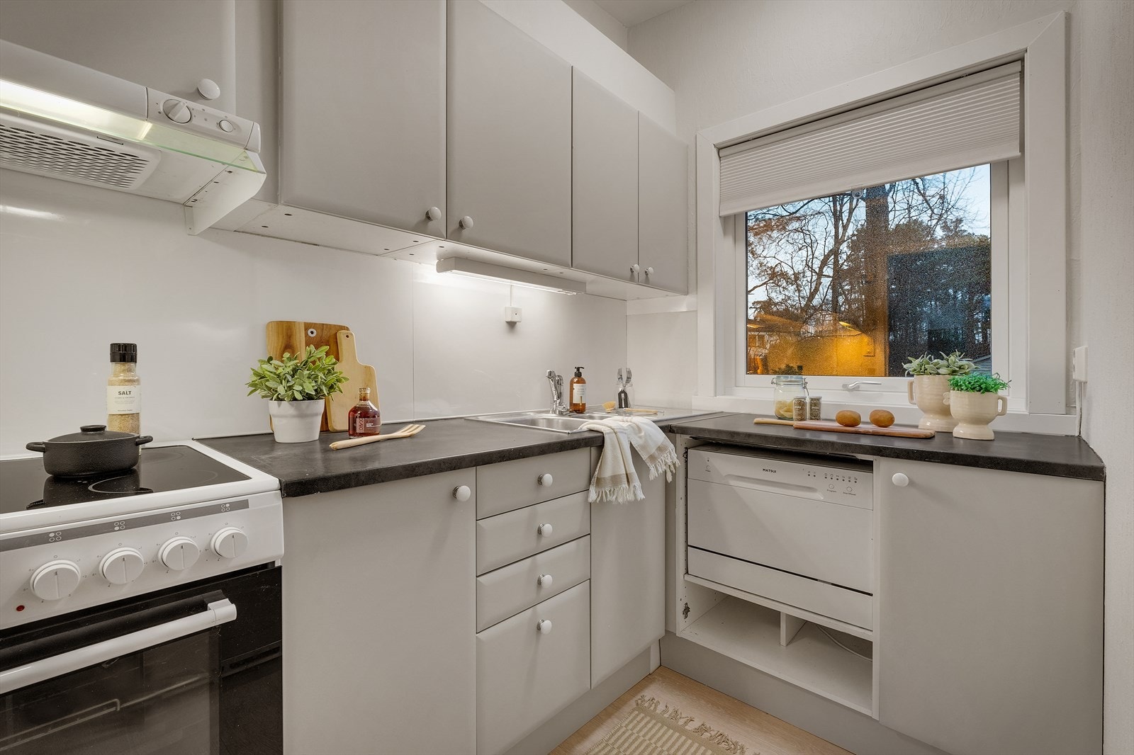 Glatte fronter, laminat benkeplater med nedfelt stålvask og godt med skapplass Galleribilde