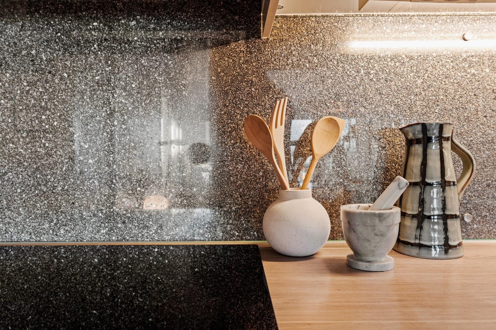 Benkeplate i laminat og glassplate på vegg mellom benk og overskap. Galleribilde