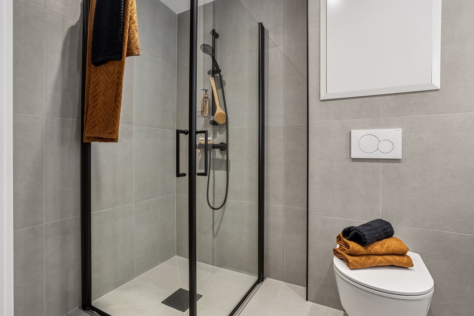 Badet har flislagt gulv med nedsenket dusjsone og vannbåren gulvvarme. Galleribilde