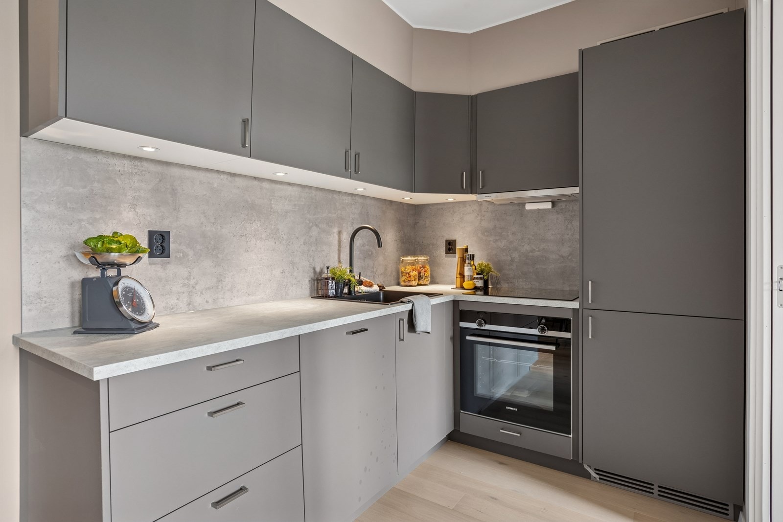 Kjøkkenet har integrerte hvitevarer: induksjonstopp, stekeovn, oppvaskmaskin, kjøleskap og fryser. Galleribilde