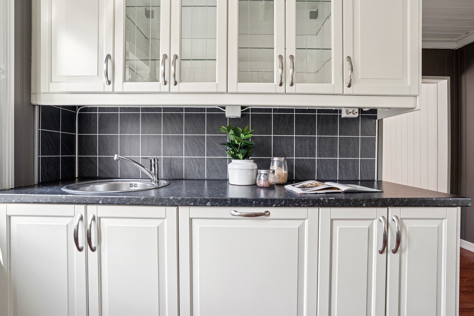 Benkeplaten er av laminat og vegg over kjøkkebenk har dekorplate. Galleribilde