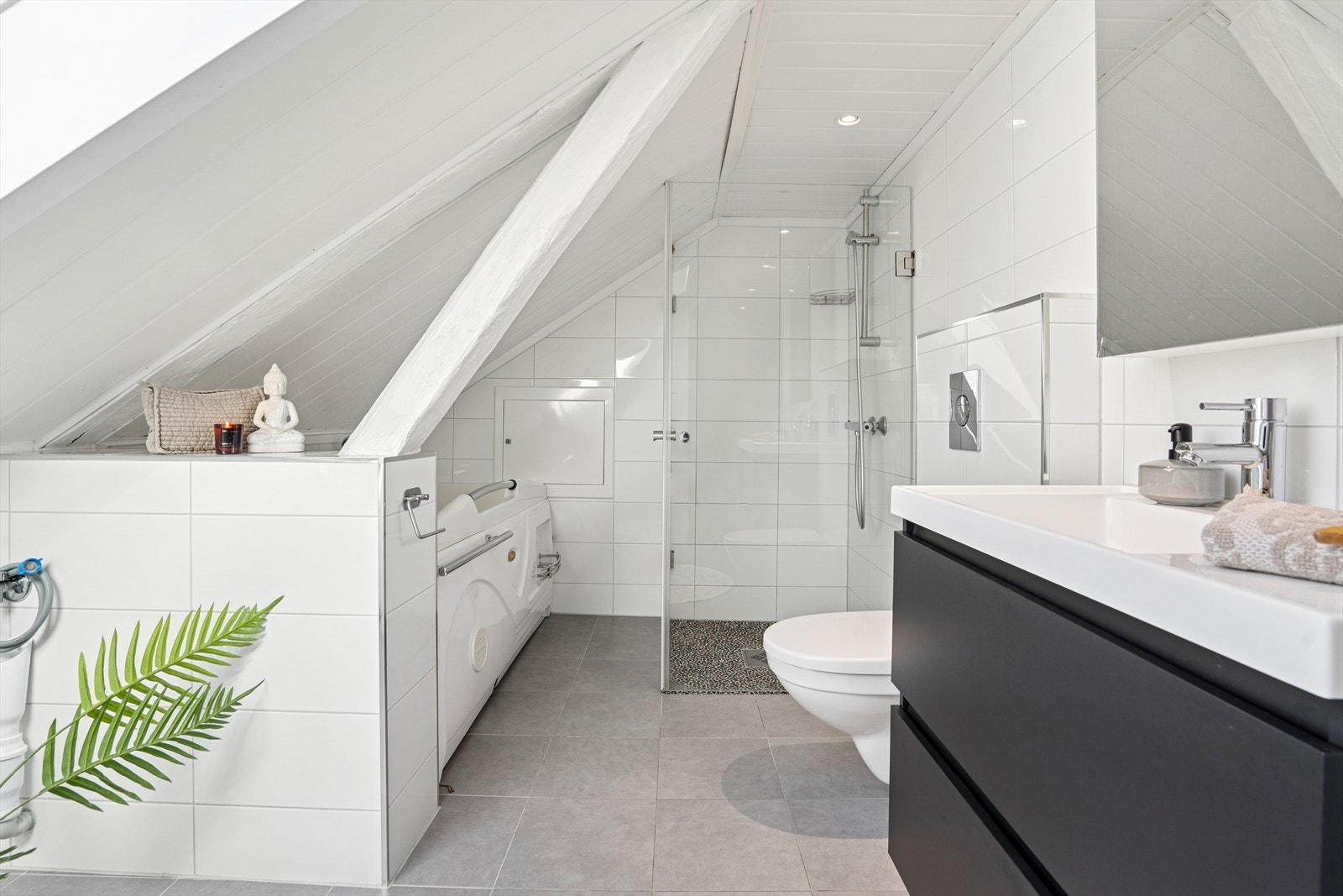 Rommet er utstyrt med nedfelt servant, overskap med speil, veggmontert toalett, badekar, dusjvegger/hjørne og opplegg for vaskemaskin. Galleribilde