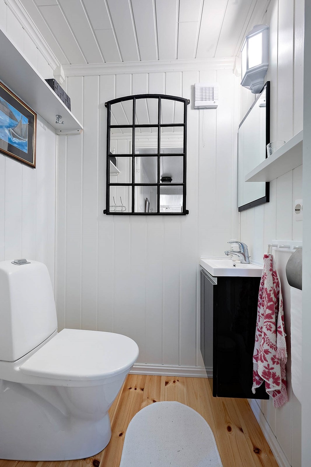 Toalettrommet er innredet med servantskap med servant, toalett og hylleplate. Galleribilde