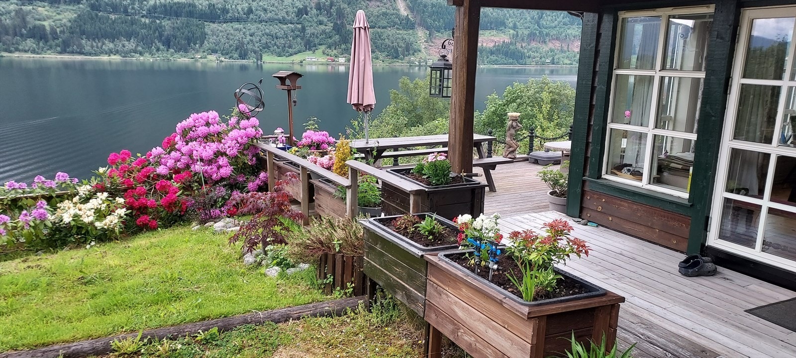 Rundt terrassen er det plantekasser og flott omramming med hage. Galleribilde