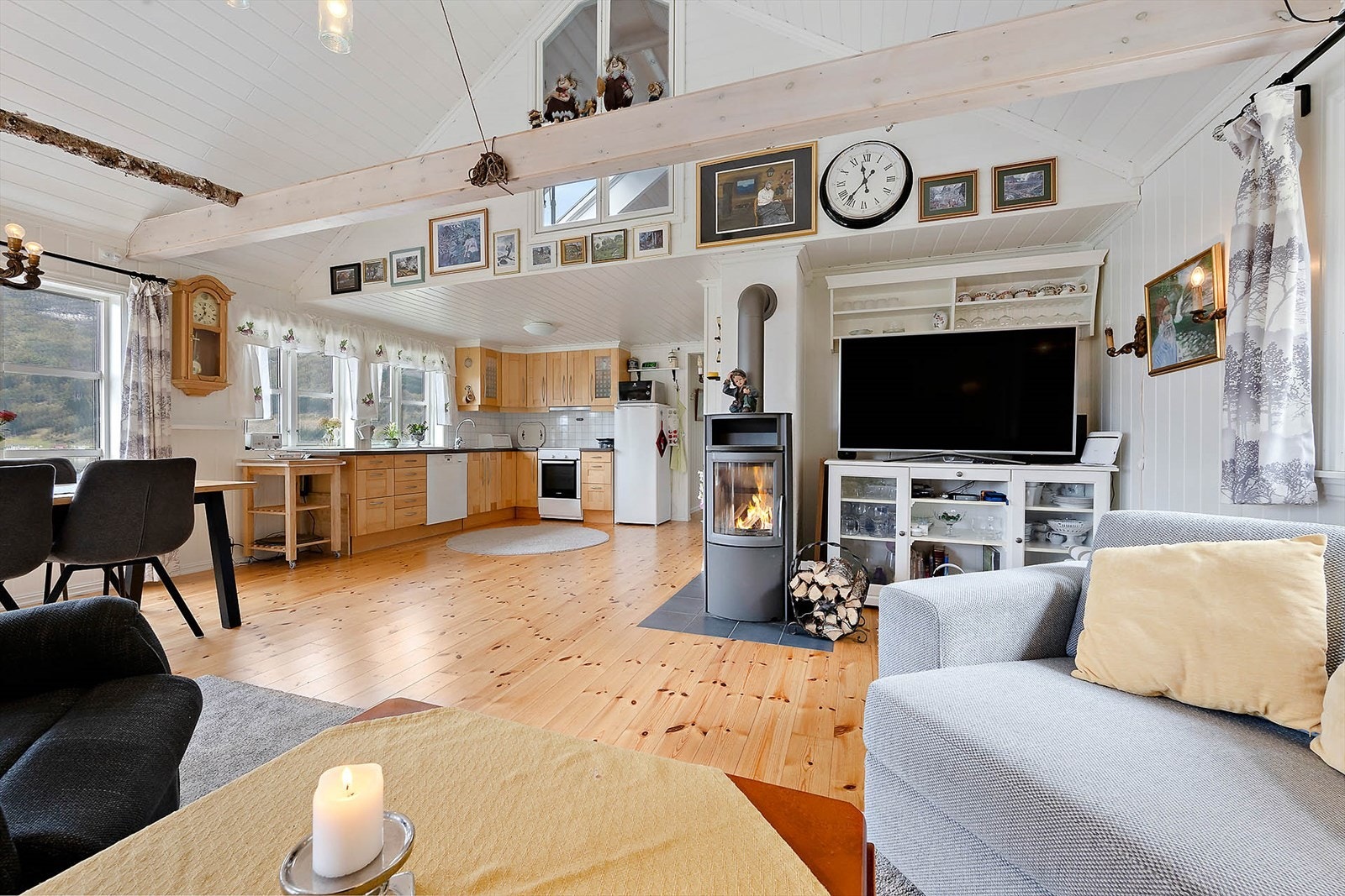 Stuen og kjøkkenet i åpen løsning med soner for matlaging, spiseområde og sofakos. Galleribilde