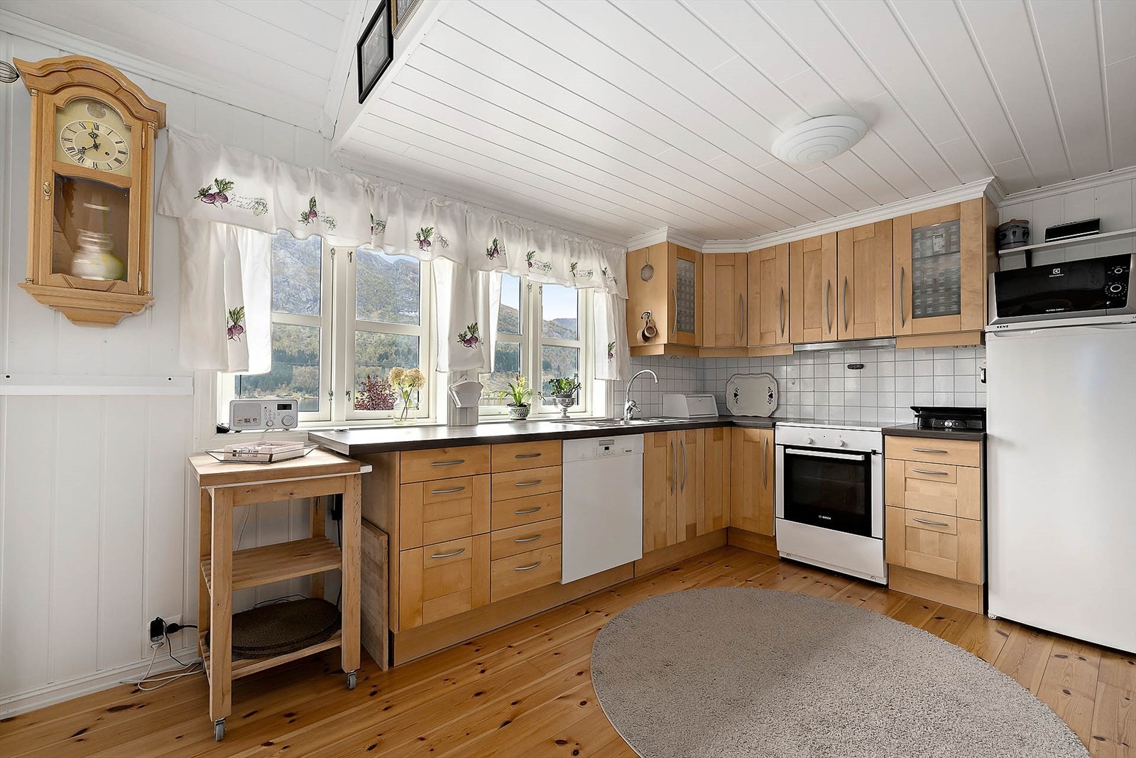 Kjøkkenet har innredning med profilerte fronter, benkeplate av laminat med stålvask og benkebeslag. Galleribilde