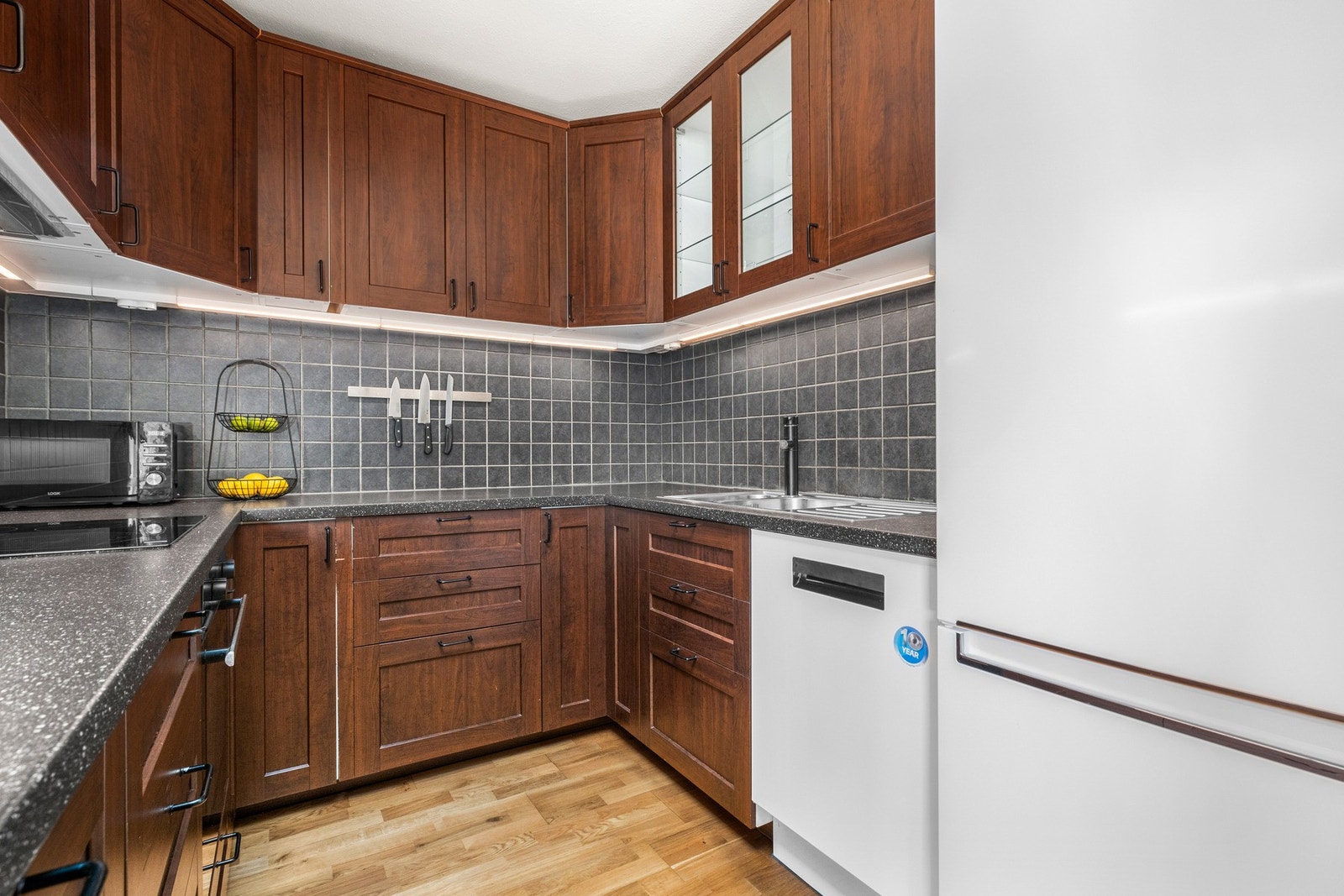 Innholdsrikt kjøkken fra 2014 med integrert stekeovn, delintegrert oppvaskmaskin og frittstående kjøle/fryseskap Galleribilde