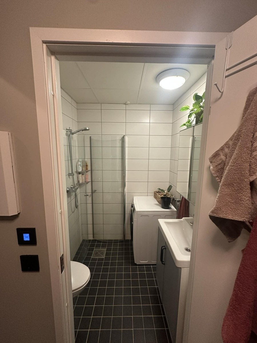 Bad med toalett, dusj, vask, speil med oppbevaring og vaksemaskin/tørketrommel.l. Galleribilde