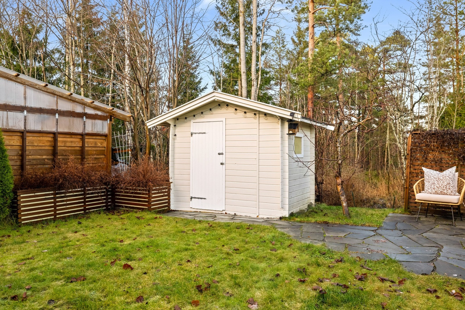 Uthus i hagen benyttes til lagring av utemøbler Galleribilde