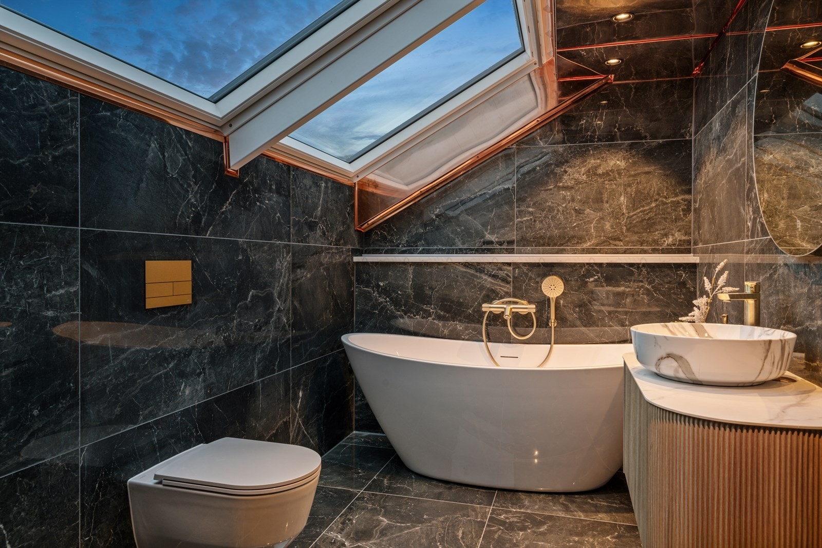 Badet er innredet med en overliggende servant, veggmontert toalett, badekar og en dusjnisje med glassdør. Galleribilde