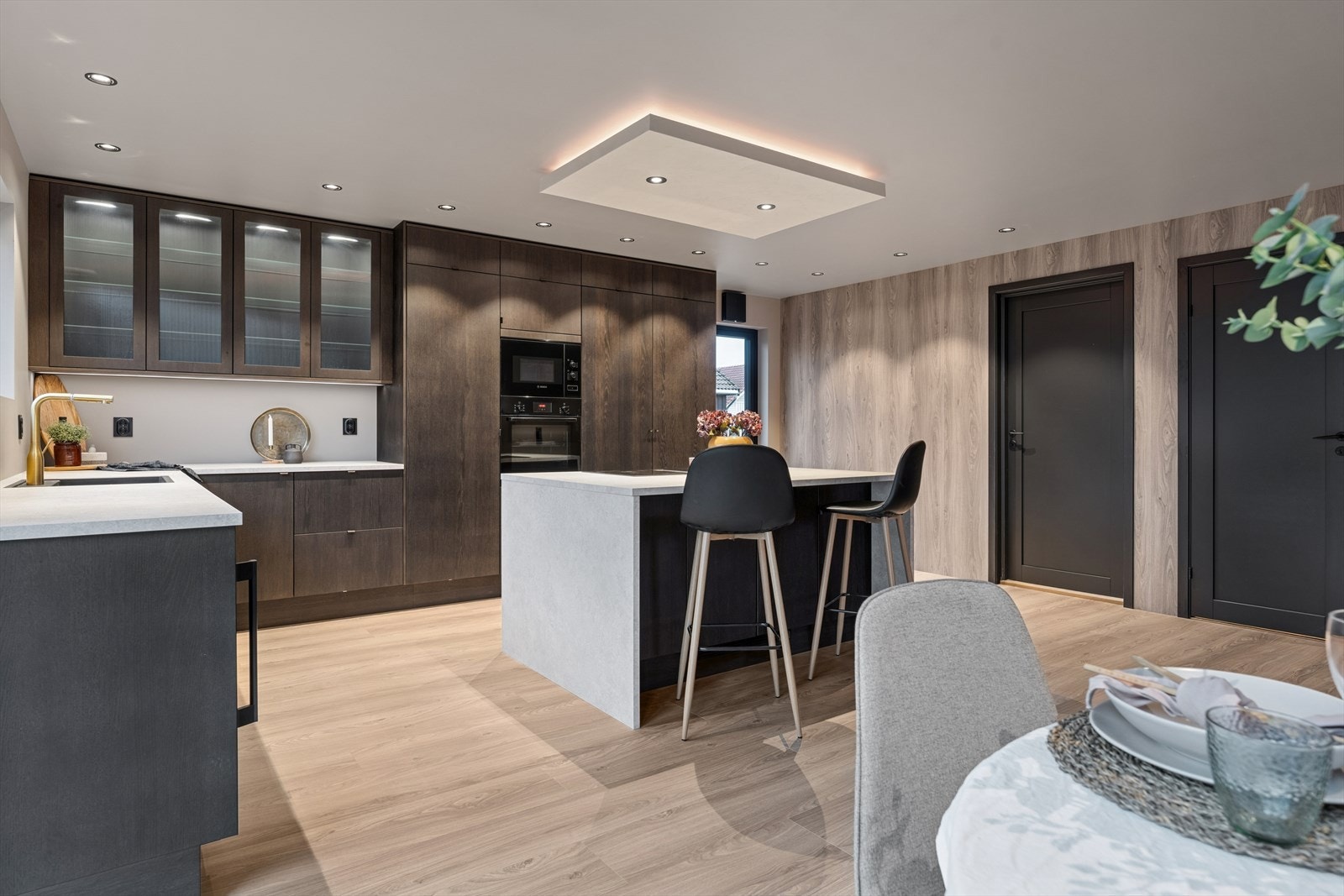 Taket har innebygde spotlights og en lysboks over kjøkkenøya som gir et varmt og behagelig lys i rommet. Galleribilde